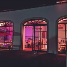 Fassadenbeleuchtung in Magenta am Dorfstadel Ziegelbach bei einer Hochzeitsfeier