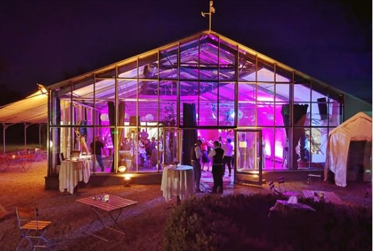 DasGlashaus in Siggenweiler bei Nacht mit Magenta-Beleuchtung während einer Hochzeitsfeier